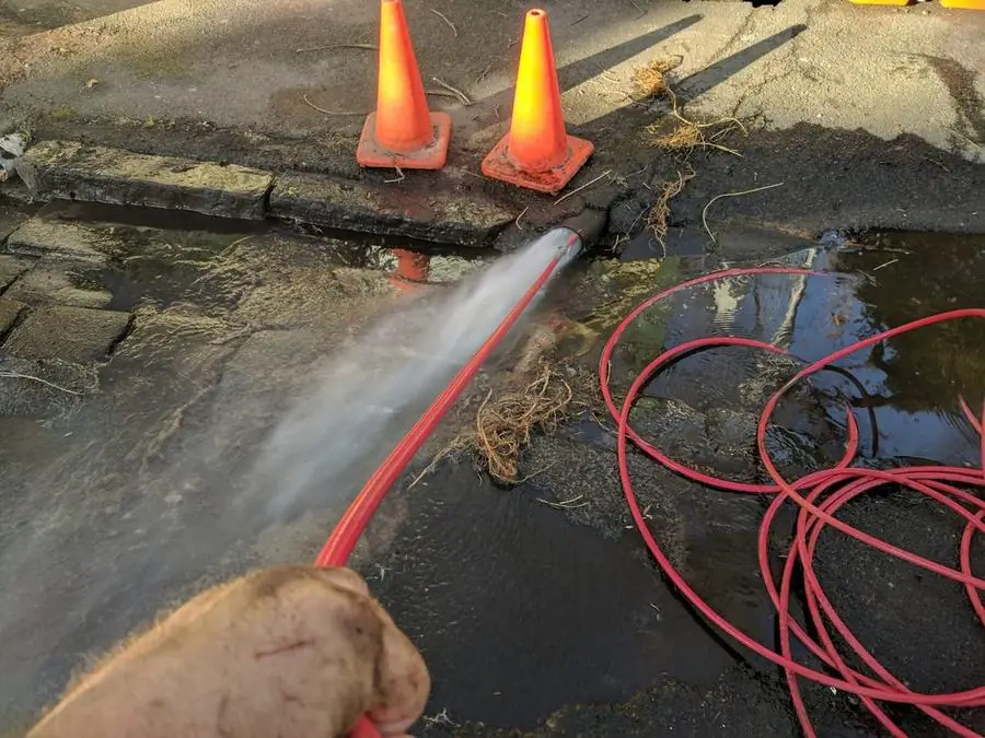 High-pressure hose clearing a stormwater pit